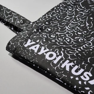 Tote Bag (Black) by Yayoi Kusama, an artist-designed object featuring abstract lines and Japanese print imagery, in black and white tones. Artwork image.